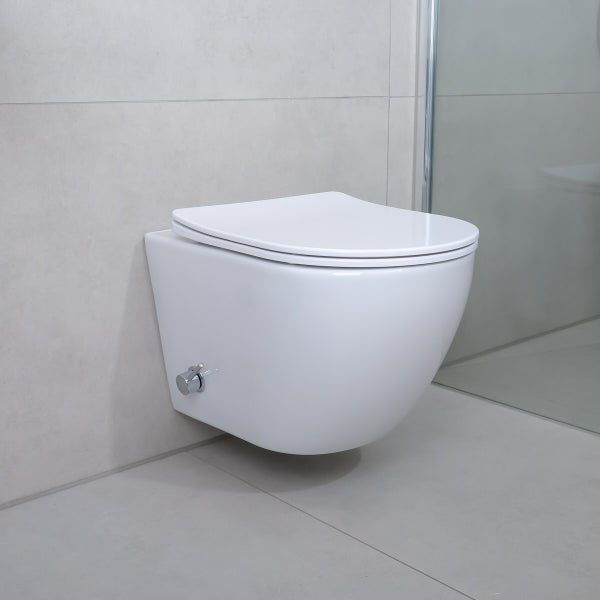 Wandhängendes Dusch-WC aus Keramik mit geschlossenem Deckel in einem hellen, modern gefliesten Badezimmer mit einer Glasduschwand.