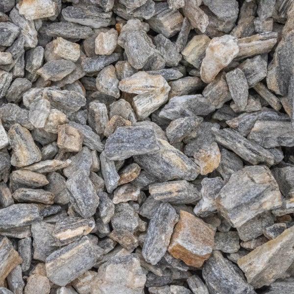 Natursteinsplitt in Grautönen und Beige, kantig gebrochen für die Gestaltung von Gärten und Wegen.