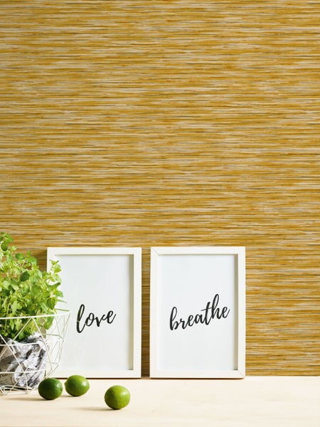 Dekorative Wand mit horizontal strukturierten Tapeten, ergänzt durch gerahmte Schilder und einen Kräutertopf