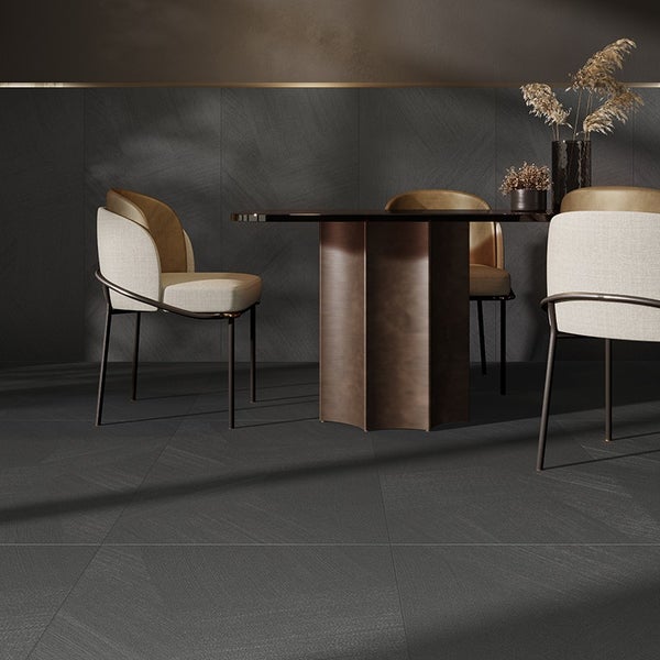 Modernes Esszimmer mit großformatigen Fliesen in Steinoptik an Wand und Boden, kombiniert mit einem runden Tisch und eleganten Stühlen.
