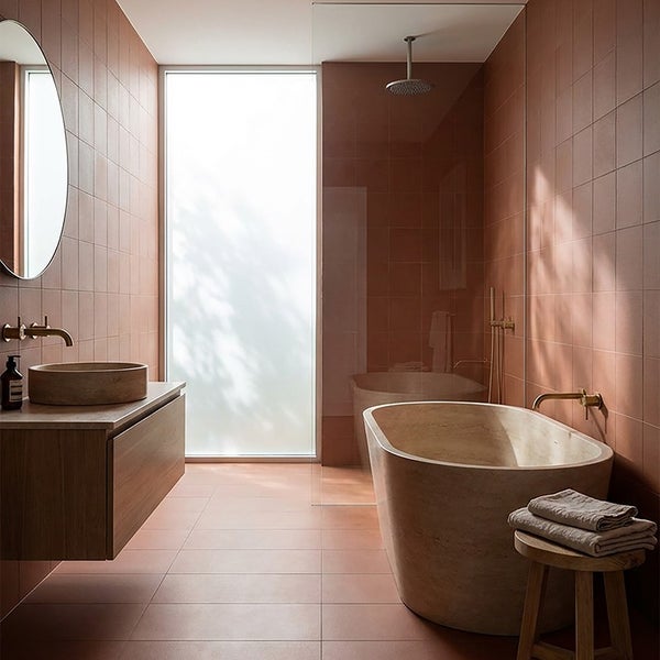 Modernes Badezimmer mit Waschtisch, freistehender Badewanne, Dusche und Wandfliesen in einem warmen Ton mit natürlichem Lichteinfall.