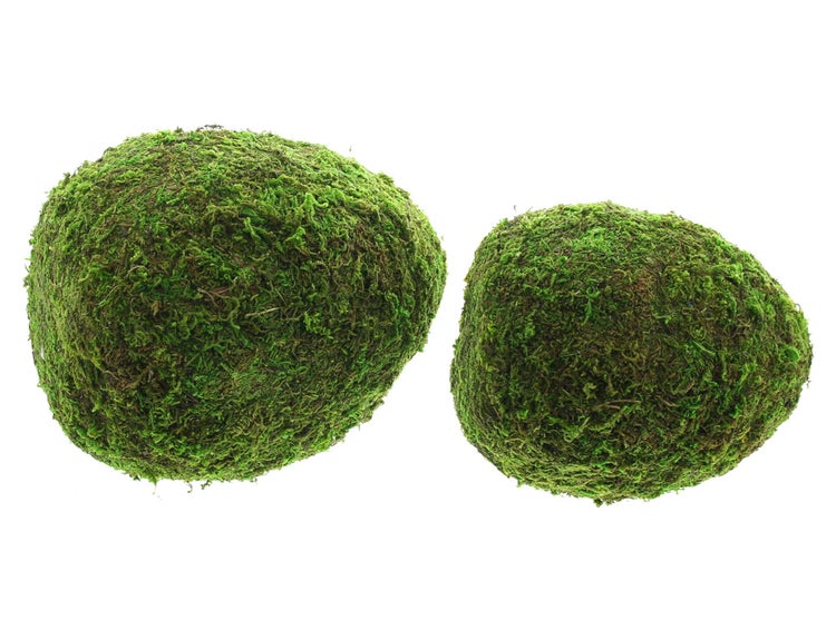 Gartenarrangement mit Blumen in geflochtenen Körben und Moos-Eiern auf einer Holzterrasse