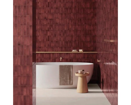Modernes Badezimmer mit vertikal verlegten Wandfliesen, einer freistehenden Badewanne und einem hölzernen Beistelltisch.