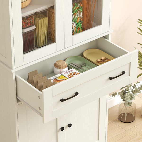 Weißer Küchenschrank mit Glastüren und einer offenen Schublade mit Tellern und Küchenutensilien.