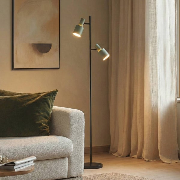 Stehleuchte mit zwei Leuchten in einem Wohnzimmer mit Sofa und Vorhängen