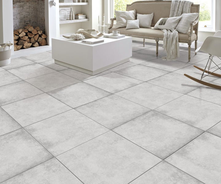 Heller Wohnraum mit modernem Fliesenboden, Sofa und Dekoration