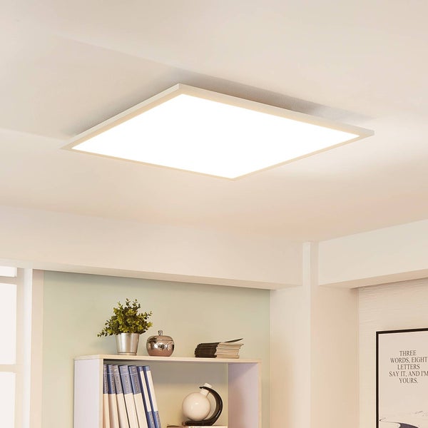 Quadratisches LED-Panel als Deckenleuchte in einem hellen Raum über einem Bücherregal montiert.