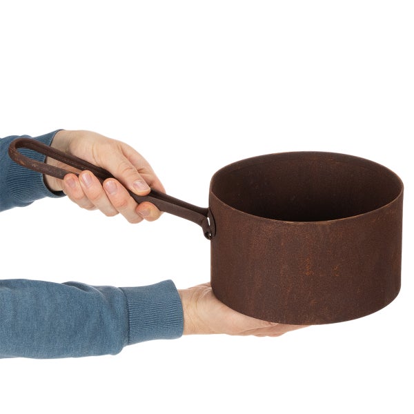 Zylindrischer Topf aus rostigem Metall mit Griff, von einer Person zur Größendarstellung gehalten.