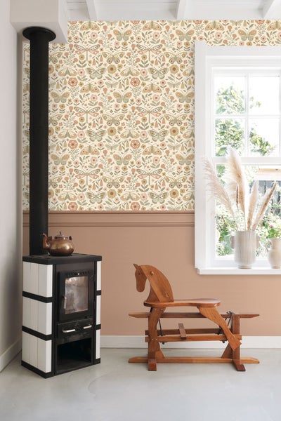 Wohnzimmer mit Ofen, Holzpferd und Tapete mit Blumen- und Schmetterlingsmuster