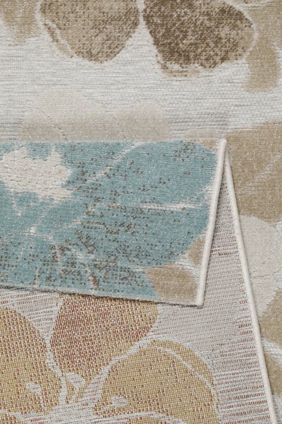 Nahaufnahme eines gewebten Teppichs mit Blumenmuster und umgeschlagener Ecke zur Ansicht der Materialstruktur und Rückseite.