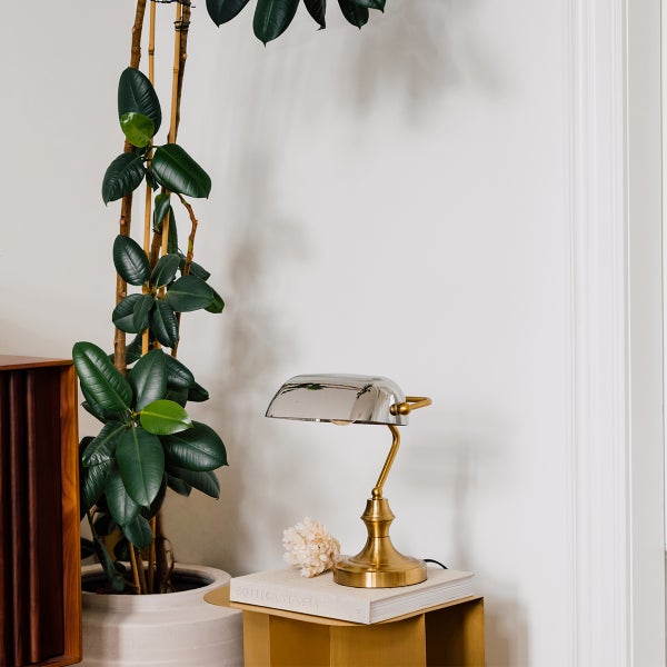 Dekorative Tischleuchte aus Metall neben einer Zimmerpflanze