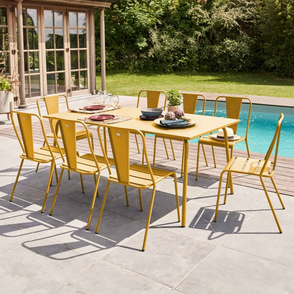 Garten-Essgruppe bestehend aus einem rechteckigen Metalltisch und acht gelben Metallstühlen auf einer Terrasse neben einem Pool.