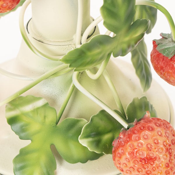 Detailansicht einer Gartenfigur mit roten Erdbeeren und grünen Blättern.