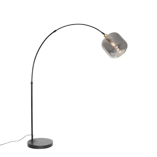 Schwarze Bogenstehlampe aus Metall mit einem rauchgrauen Glasschirm und rundem Standfuß.