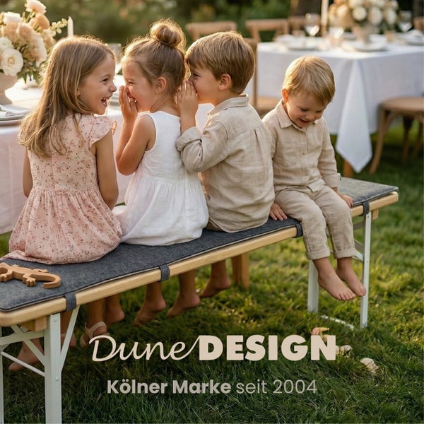 Kinder sitzen auf einer Bierzeltgarnitur mit grauer Sitzauflage im Garten bei einer Feier. Dune Design Logo.