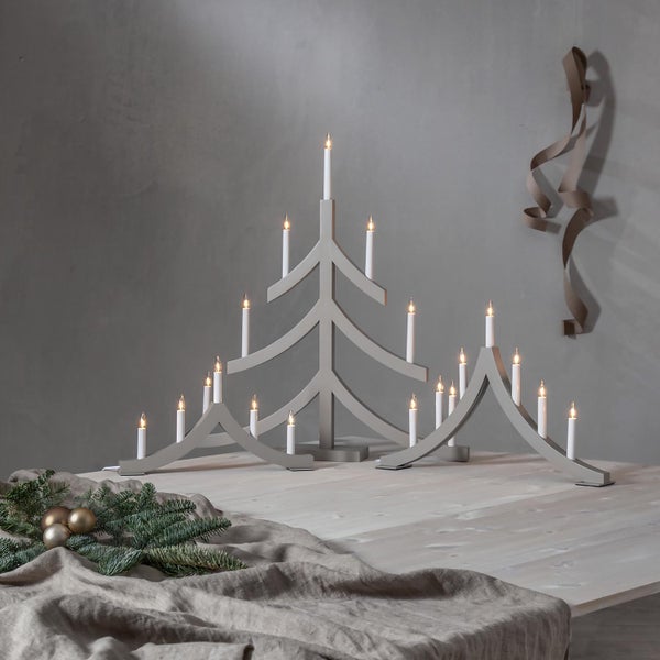 Grauer Weihnachtsbaum Kerzenhalter mit Kerzen auf einem Tisch.