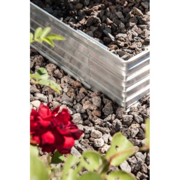 Wellblech-Beetumrandung aus Metall in einem Garten mit Lavasteinen und einer Rose