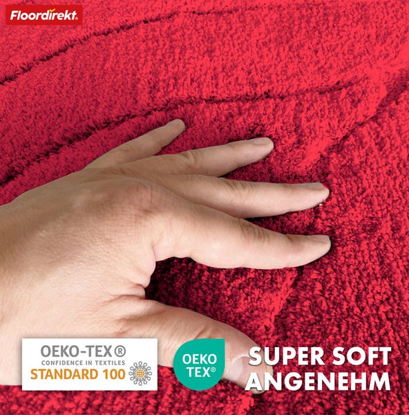 Nahaufnahme eines roten Badteppichs mit Hand und den Logos Oeko-Tex Standard 100 und Oeko-Tex