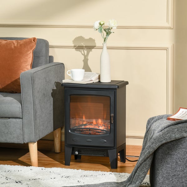 Freistehender Elektrokamin mit Flammeneffekt in einem hellen Wohnzimmer neben einem Sofa aus Textil.