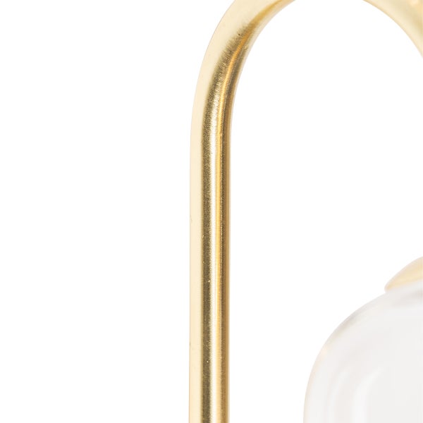 Detail einer goldenen Halterung und eines transparenten Glases