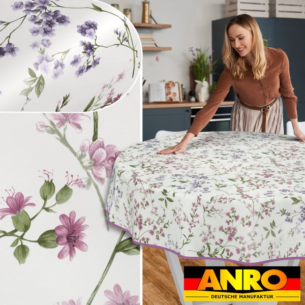 Frau legt Wachstuch Tischdecke mit Blumenmuster auf Küchentisch