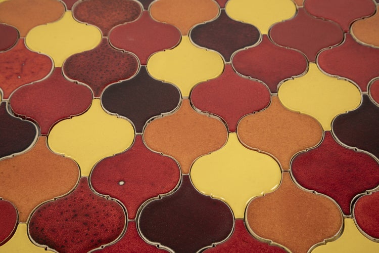 Muster aus roten, gelben und braunen Mosaikfliesen