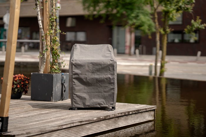 Grill mit Schutzhülle auf einer Holzterrasse im Freien