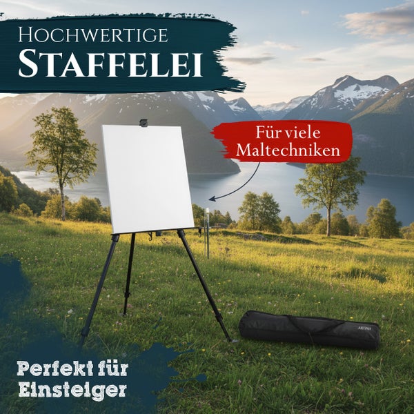 Eine dreibeinige Feldstaffelei mit Leinwand auf einer Wiese vor einer Berglandschaft mit Tragetasche.