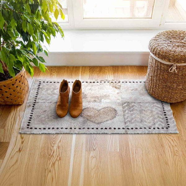Fußmatte mit Herzmuster, Schuhen und Korb neben einer Zimmerpflanze vor dem Fenster