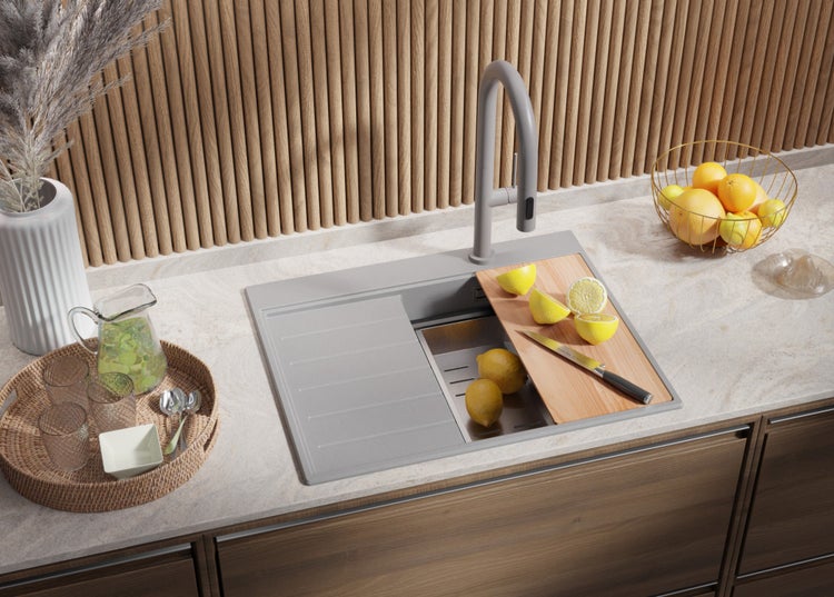 Küchenspüle mit Armatur, Schneidebrett und frischen Zitrusfrüchten auf einer Küchentheke