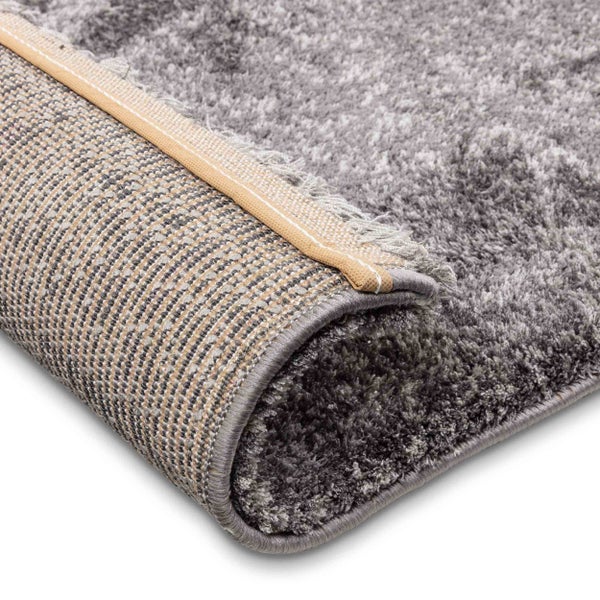 Hochflor-Teppich in Grau mit weicher Oberfläche, gewebter Rückseite und geketteltem Rand.