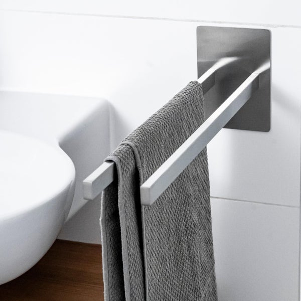 Doppelter Handtuchhalter aus Metall zur Wandmontage mit aufgehängtem Handtuch im Badezimmer.