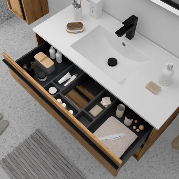 Moderner Waschtischunterschrank in Holzoptik mit weißem Waschbecken, schwarzer Armatur und Auszug mit Ordnungssystem für Badutensilien.
