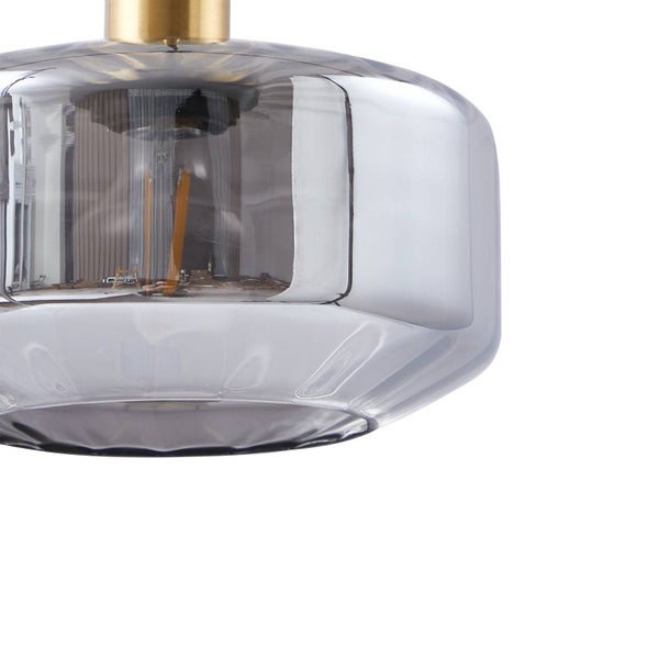 Nahaufnahme eines zylindrischen Lampenschirms aus Rauchglas mit einer messingfarbenen Metallfassung an der Oberseite.