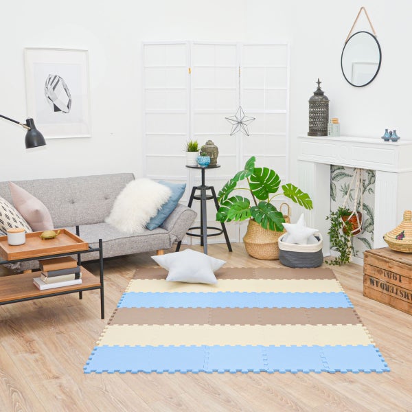 Helles Wohnzimmer mit einer gestreiften Schaumstoff-Spielmatte, einem Sofa, Holzmöbeln und Zimmerpflanzen.