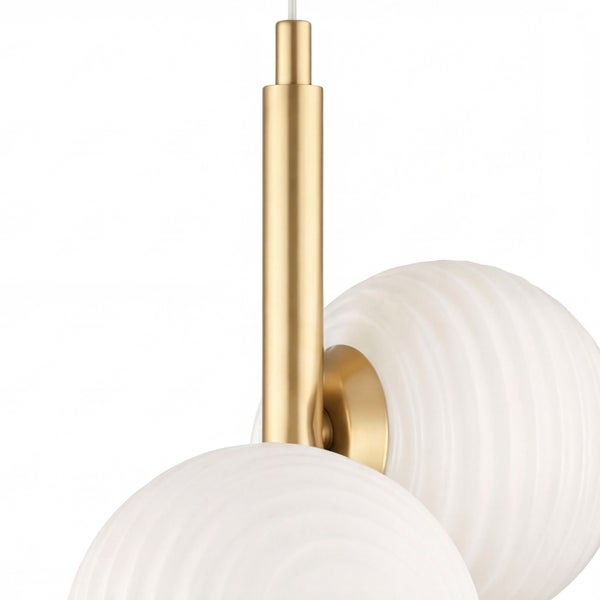 Nahaufnahme einer Pendelleuchte mit goldfarbenem Metallstab und weißen, geriffelten Glaskugeln.