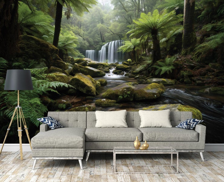 Wohnzimmer mit grauer Couch und Wandtapete mit Waldmotiv inklusive Wasserfall und Farnen