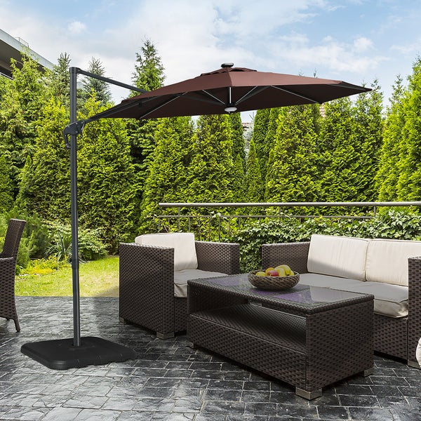 Szene mit Ampelschirm, Sitzgruppe und Gartentisch auf einer Terrasse