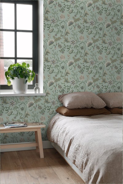 Schlafzimmer mit floraler Tapete, Bett und Fenster für eine helle und einladende Atmosphäre.