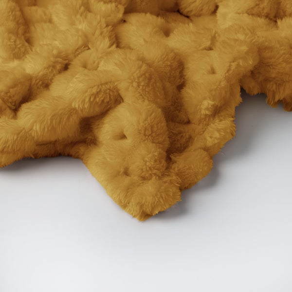 Nahaufnahme einer flauschigen Kuscheldecke aus Kunstfell in Senfgelb.