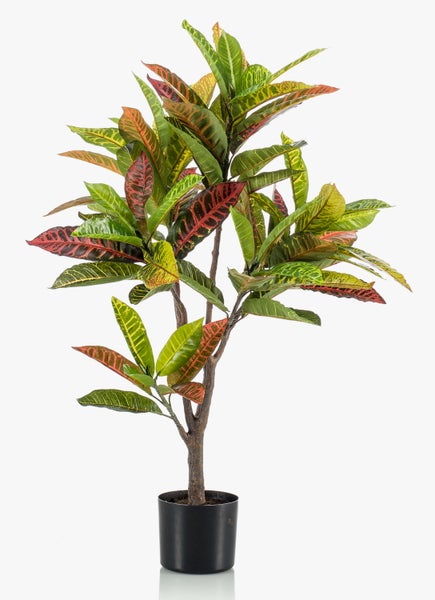 Künstliche Croton Pflanze im schwarzen Kunststofftopf mit bunten Blättern.