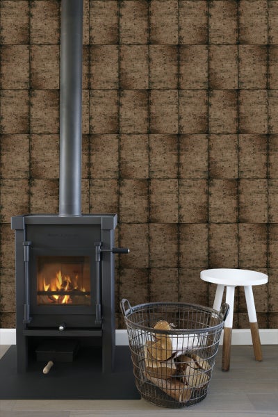Wohnzimmer mit Kaminofen, Holzkorb und Wandtapete in Steinoptik