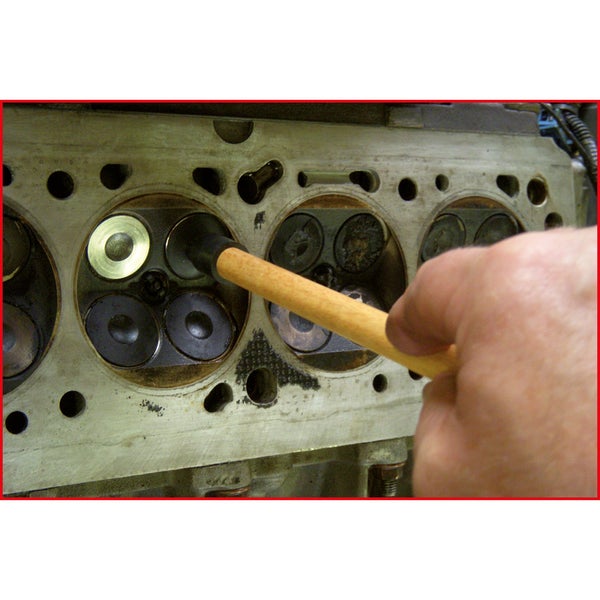 Nahaufnahme eines Ventilschaftdichtungsinstallationswerkzeugs, das an einem Zylinderkopf verwendet wird.