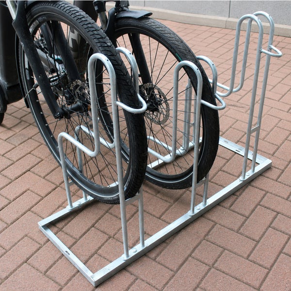 Fahrradständer aus verzinktem Stahl für drei Fahrräder auf einem gepflasterten Untergrund