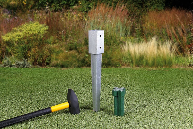 Ein Hammer schlägt einen Erdanker in den Boden