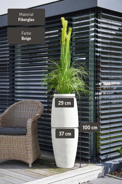Beigefarbener Pflanzkübel aus Fiberglas, 100 Zentimeter hoch und 37 Zentimeter breit, auf einer Terrasse neben einem Korbsessel.