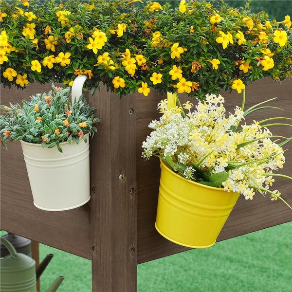 Blumenkasten mit gelben und weißen Blumen in dekorativen Behältern