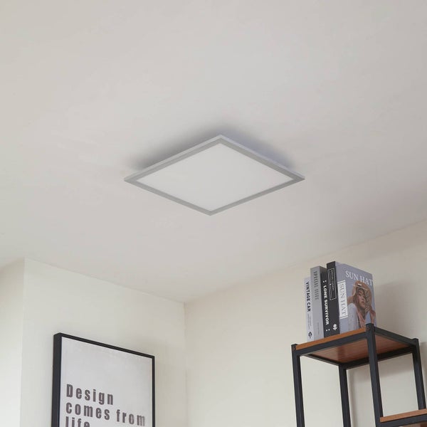 Quadratisches LED-Deckenpanel mit silbernem Rahmen montiert an einer weißen Decke in einem modern eingerichteten Raum.