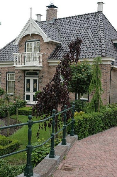 Haus mit Ziegeldach, Balkon und Garten
