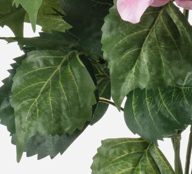 Detailaufnahme eines künstlichen Pflanzenstiels mit grünem Blatt aus Kunststoff.